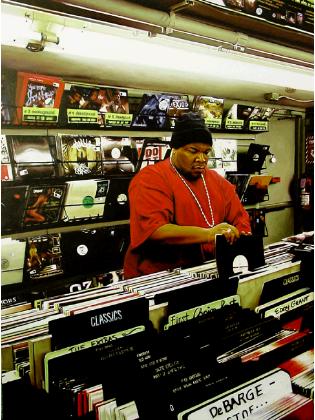 hunger- hyperrealism acrylic painting by artist painter Gerard Boersma showing afro-american man going throuh hiphop records in vinyl music store beatstreet brooklyn new york, digging in crates