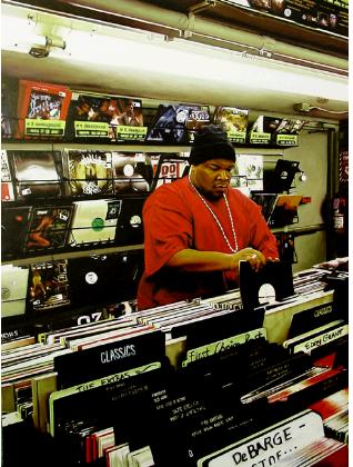 hunger- hyperrealism acrylic painting by artist painter Gerard Boersma showing afro-american man going throuh hiphop records in vinyl music store beatstreet brooklyn new york, digging in crates