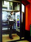 cage- hyperrealism acrylic painting by artist painter Gerard Boersma showing a man in front of parking automat in newly build parking garage in Leeuwarden