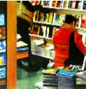 searching- hyperrealism painting by artist Gerard Boersma showing woman wearing red jacket squatting down for some books in local bookstore