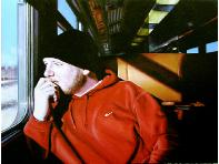 The Trip- hyperrealism public transport painting of man riding a train by artist Gerard Boersma